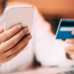Female hand holding smartphone and credit card