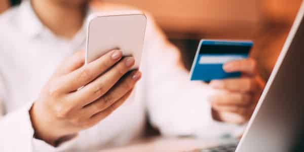 Female hand holding smartphone and credit card